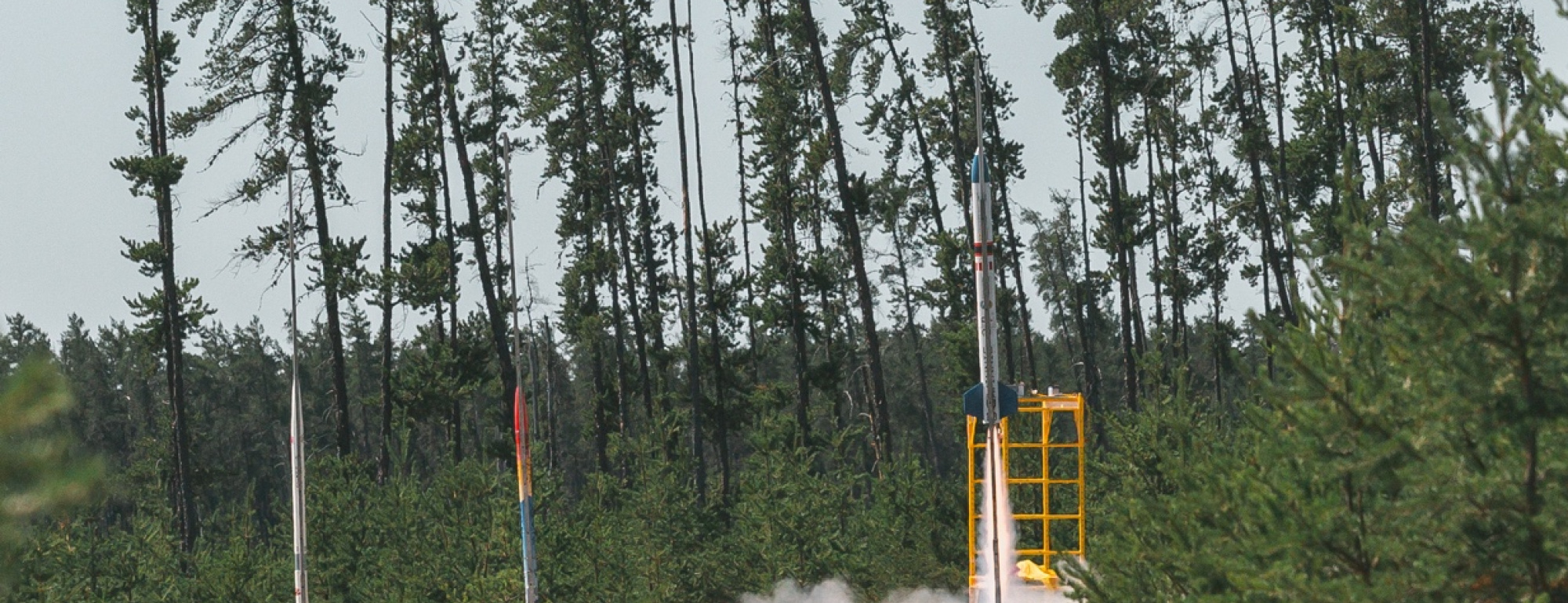 small rocket launch surrounded by trees