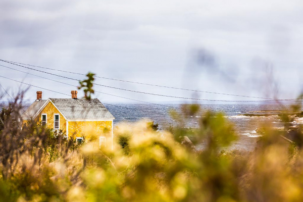 Yellow house sitting against grey background in Canso, NS